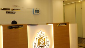 A reception desk with a logo, a 'May I Help You' sign, a 'Reception' sign, and a 'No Smoking' sign. - S S RESIDENCY (Gorakhpur)