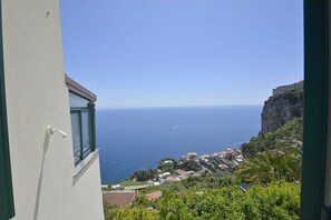 Blick auf die Küste mit einem Gebäude, einer Klippe und dem Meer.