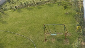 A grassy area with a swing set. - Hotel Deluxe And Family Resturant (Lachhmangarh)