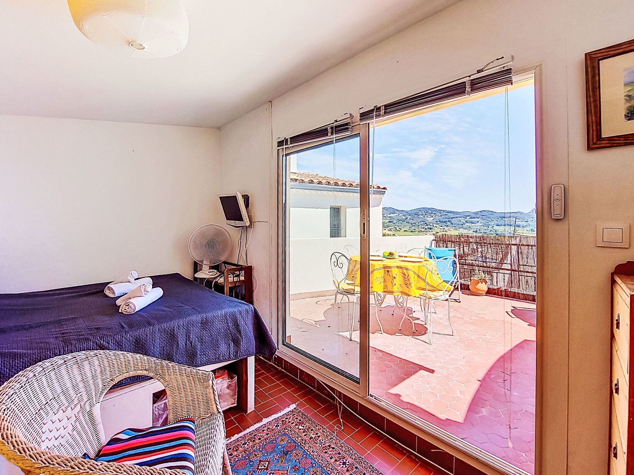 Une chambre avec un lit, une chaise, une table et un balcon offrant une vue.