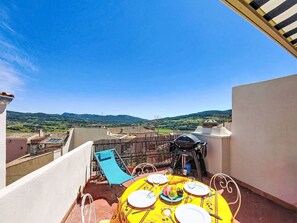 A rooftop terrace with a table set for dining, a grill, and a blue chair. - Vacation home La Vue by Interhome (La Cadière d'Azur)