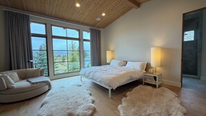 A bedroom with a large window, a bed, a sofa, and a fur rug. - Sawtooth Sunsets in Stanley, Idaho (Stanley)