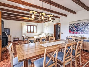 Un coin repas avec une table et des chaises en bois, une cheminée et un grand tableau accroché au mur.