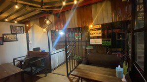Un interior acogedor con una escalera de madera, una recepción y un cartel que indica que se trata del Doko Resort en Kanyam.