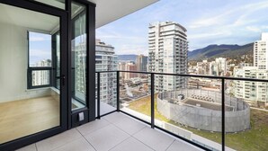 Ein Balkon mit Blick auf die Stadt, moderne Gebäude und ein klarer Himmel.