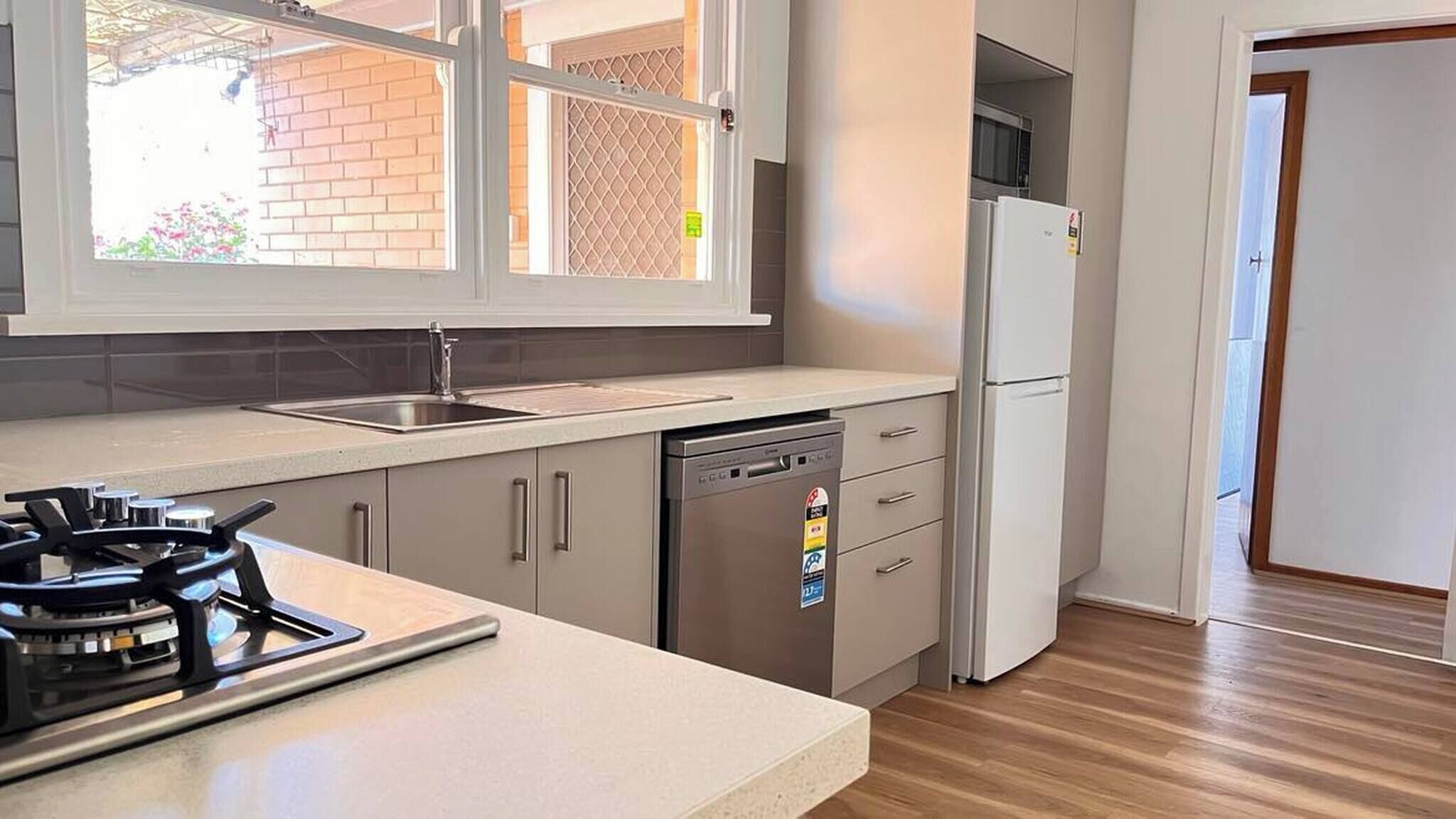 A kitchen with a gas stove, dishwasher, and a refrigerator.