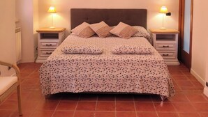 A bedroom with a bed, two bedside tables with lamps, a chandelier, and a framed picture on the wall. - The Red house 1930 - frontside seaview apartment (Lido di Ostia)