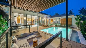 A modern house with a pool, outdoor seating, and a covered patio area. - Julia Villa Bali (Gianyar)