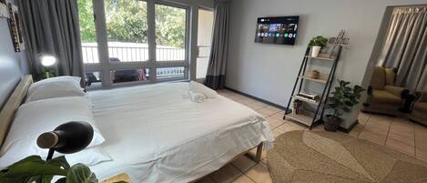Tabla de planchar con plancha, internet y ropa de cama
