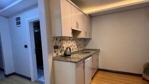 Una cocina con lavavajillas, cafetera y salpicadero de azulejos.