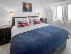 A bedroom with a bed, two bedside tables, a nightstand, a window, and a painting on the wall. - 3 bedroom accommodation in Roag, near Dunvegan (Roag, near Dunvegan)
