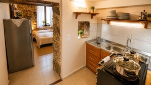 Una cocina compacta equipada con refrigerador, estufa, lavamanos y armarios de madera.