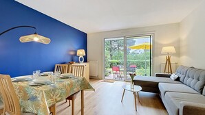 Ein Essbereich mit Tisch für vier Personen, einer Couch und Blick ins Freie.