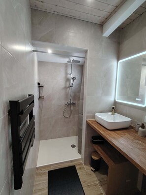 A modern bathroom with a shower, a sink, and a mirror. - Maisonnette avec terrasse (Saint-Gilles-Croix-de-Vie)