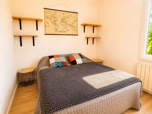 Une chambre à coucher avec un lit, une carte accrochée au mur et deux tables de chevet.