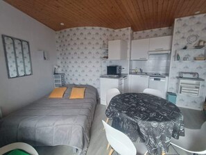 Un dormitorio con cama, escritorio y kitchenette.