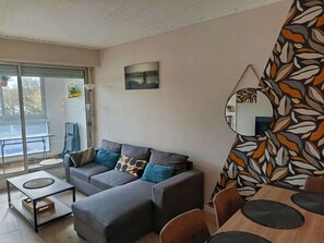 En stue med sofa, sofabord og spiseområde med stole.