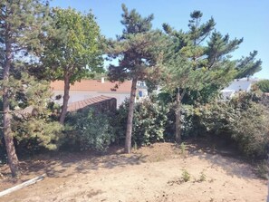 Ein Wohngebiet mit Bäumen, einem Feldweg und einem Haus mit roten Ziegeln.
