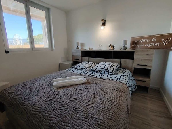 Una camera da letto con un letto, comodini, abat-jour e una finestra vista.