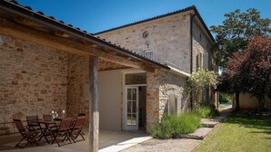 A stone building with a covered patio, outdoor seating, and a view of the surrounding landscape. - Villa Eva Rustica (100591-K1) - Zbandaj (Zbandaj)