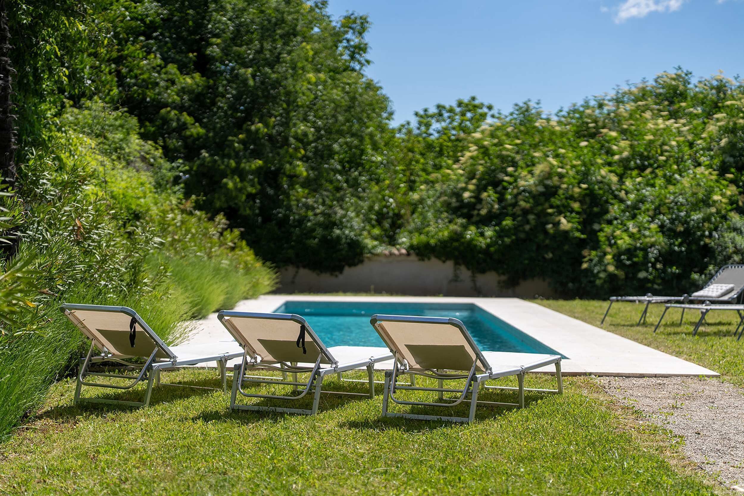 A pool area with lounge chairs and a clear view of the pool.