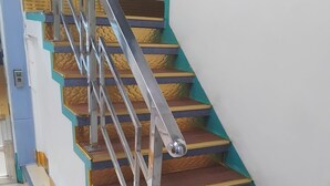 A staircase with metal railings and wooden steps. - TRANSIT HOTEL  LUXUARY (Male)