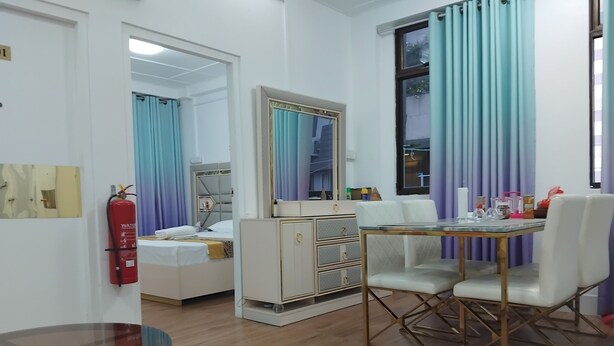 A hotel room with a bed, bedside table, wardrobe, dining table with chairs, and a glass coffee table. - TRANSIT HOTEL  LUXUARY (Male)