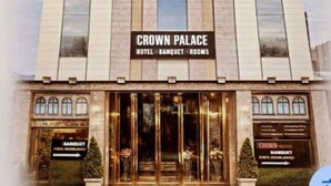 Un edificio con un cartel que dice 'Crown Palace Hotel - Banquet - Rooms'.