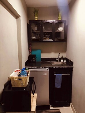 Eine kleine Küche mit Kühlschrank, Spüle und Schränken.