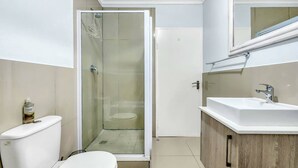 Ein Badezimmer mit Toilette, Duschkabine und Waschbecken.