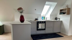 Una cucina moderna con isola centrale, forno a incasso e un lucernario.