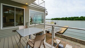 A deck with a table and chairs, overlooking a body of water and a forested area. - Hull Bay Waterfront Home: Private Dock & Apartment (Hull)