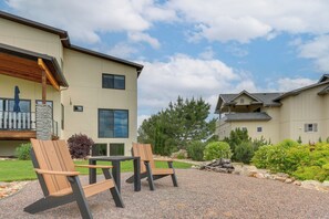 Un bâtiment moderne doté d’un patio comprenant deux fauteuils Adirondack et une table.