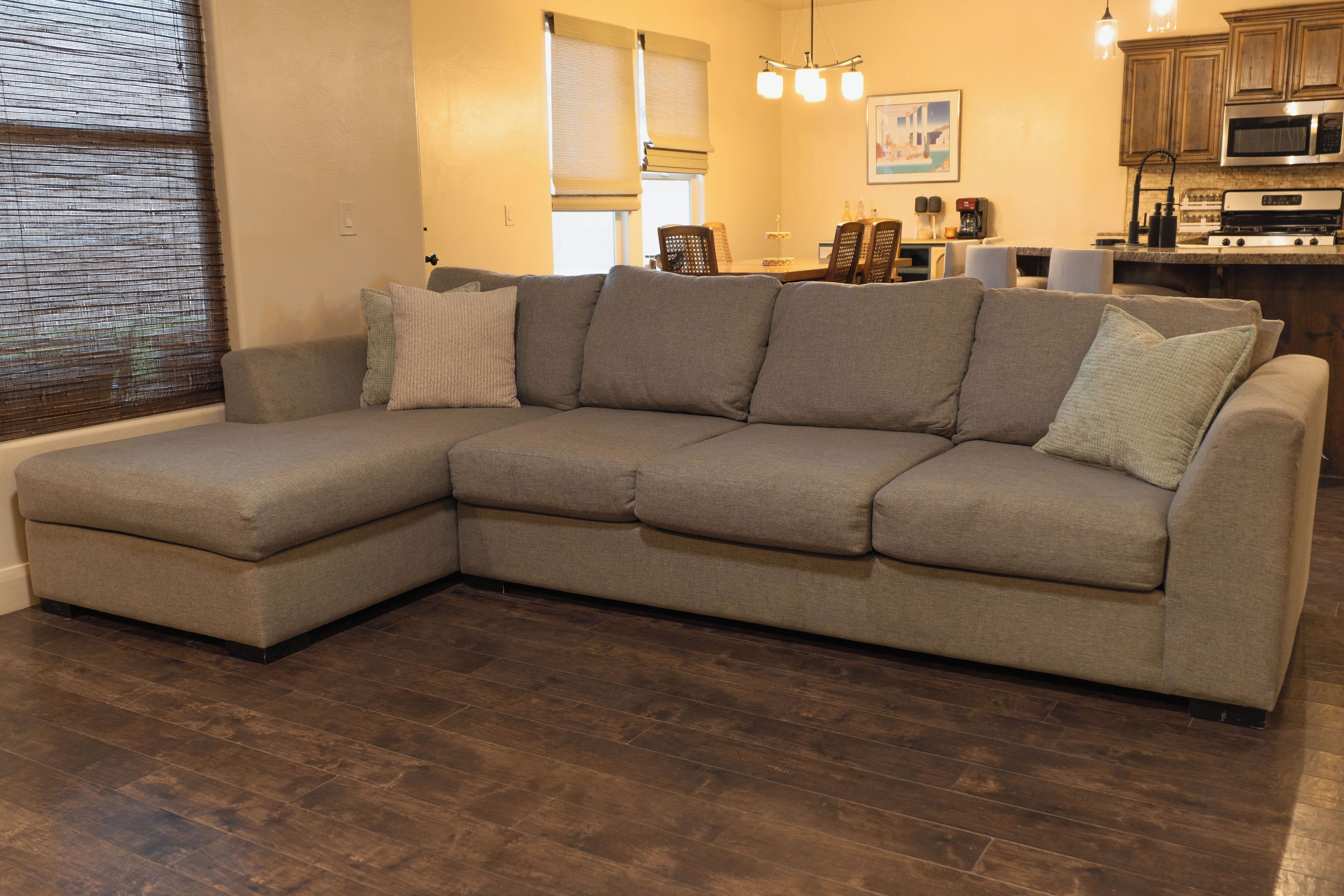 Ein Ecksofa in einem Wohnzimmer mit Holzboden.