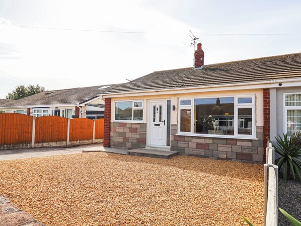 A residential house with a front garden, a wooden fence, and a tiled roof. - 6 Bastion Close (Prestatyn)