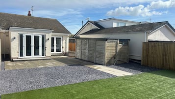 A residential property with a patio, a garage, and a fenced yard.