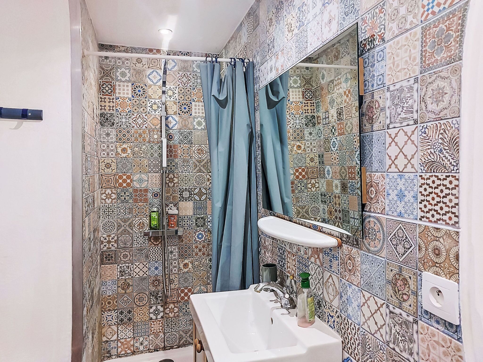 Une salle de bain avec une douche, un lavabo et un miroir.
