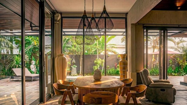 An indoor dining area with a round table, chairs, and hanging light fixtures. - Kokokan Villa Ubud (Gianyar)