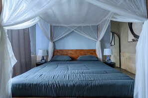 A bed with a canopy, two bedside tables with lamps, and a wall with artwork. - Kokokan Villa Ubud (Gianyar)