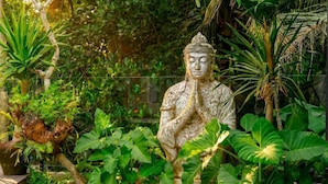 A statue in a garden with various plants. - Kokokan Villa Ubud (Gianyar)