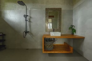 A bathroom with a shower, a mirror, a wooden vanity, and a hexagonal tile wall. - Kokokan Villa Ubud (Gianyar)