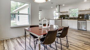 Una cocina moderna con comedor, ventanas amplias y vistas al exterior.