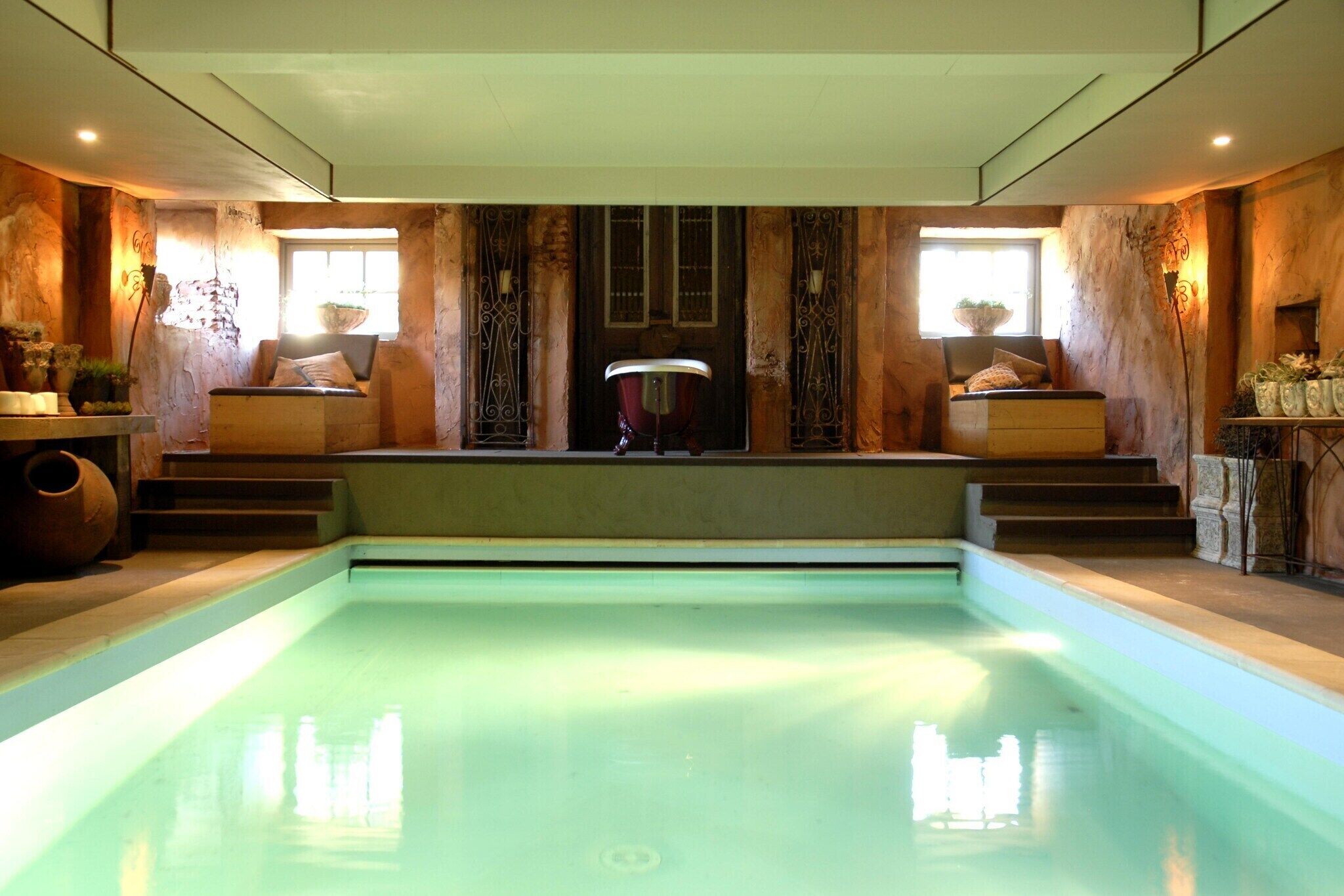Ein Pool mit Stufen, Holzverkleidung und einem Fenster mit einer Pflanze.
