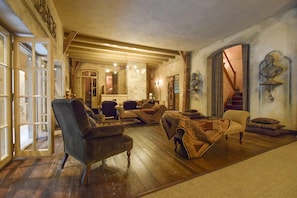 Un vaste salon doté d’un plancher en bois, d’un escalier et offrant une vue sur l’extérieur.