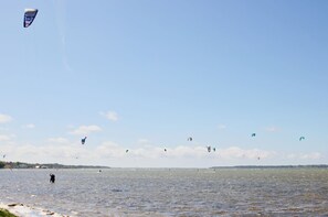 A wide view of a body of water with multiple kites flying, and a person standing on the shore. - Surfer's Paradise Wiek - Surfer's Paradise Wiek - Holiday apartment Lee (Wiek)