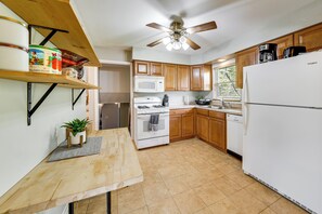 A kitchen with wooden cabinets, a white refrigerator, a microwave, a stove, and a ceiling fan. - 2 Mi to I-88 & Hospital! Extended Naperville Stay (Naperville)