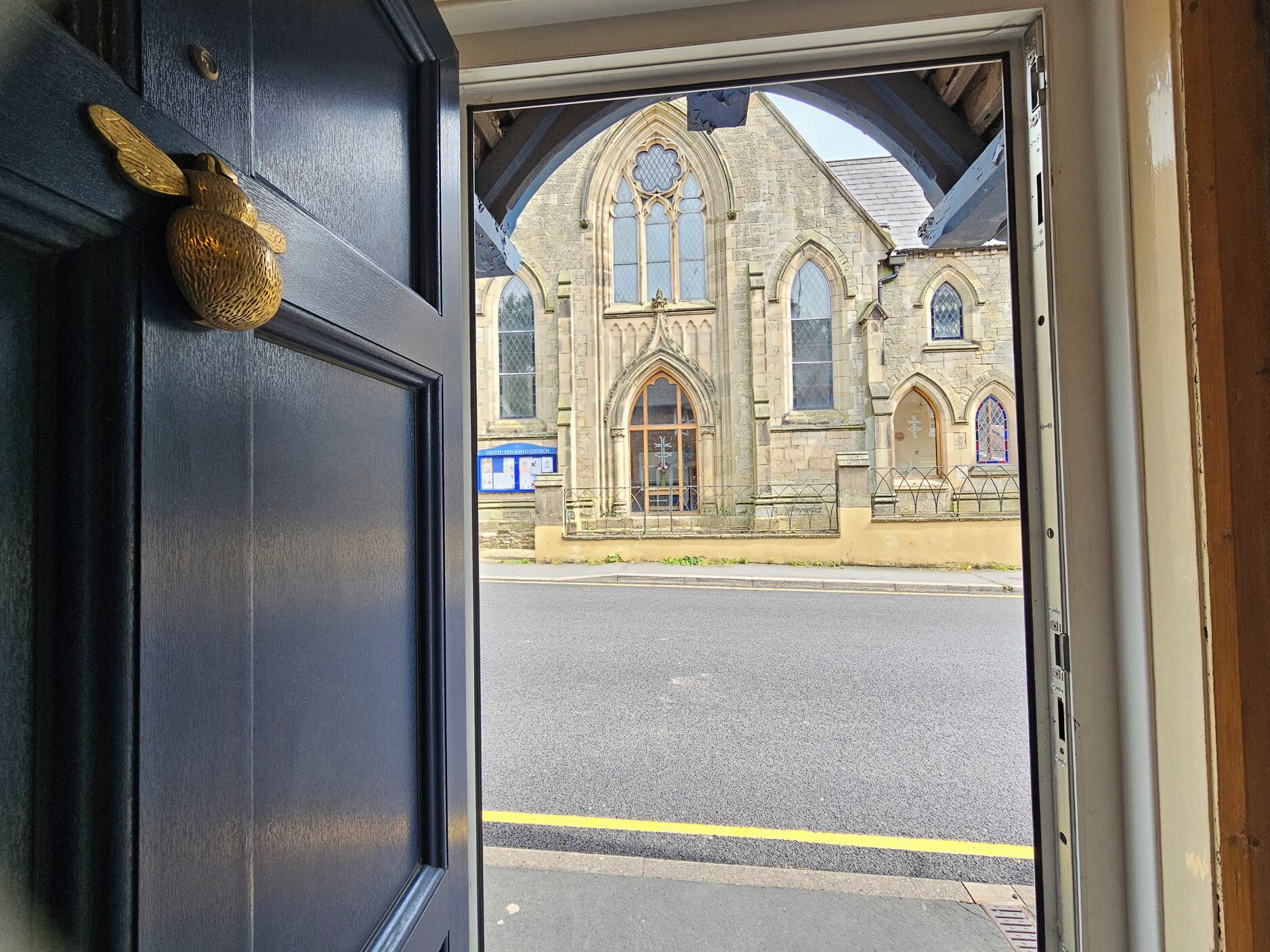 A doorway leading to a building with Gothic architecture, including pointed arches and stained glass windows.
