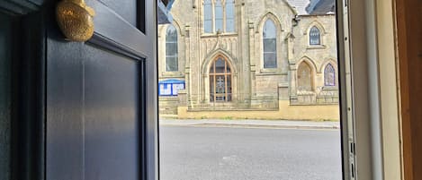 A doorway leading to a building with Gothic architecture, including pointed arches and stained glass windows.