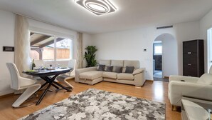A modern living room with a sectional sofa, a dining table, and a large rug. - Family-Friendly Calpe Home with Pool (Calpe)