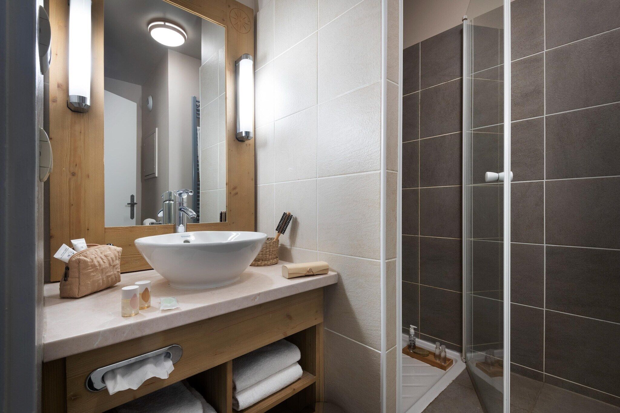 Un bany amb un lavabo gran, mirall i dutxa.